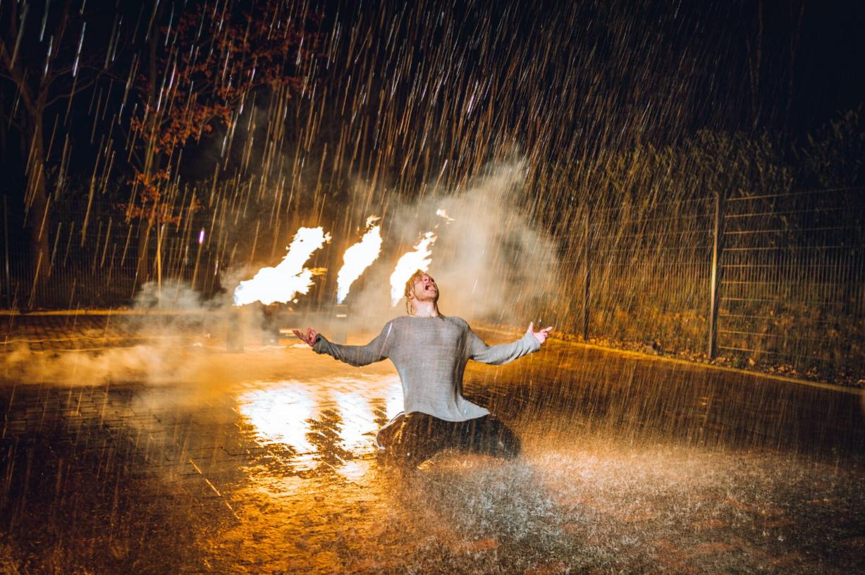 Skeptika bei einem Musikvideodreh im Feuerwehrregen und vor Flammen